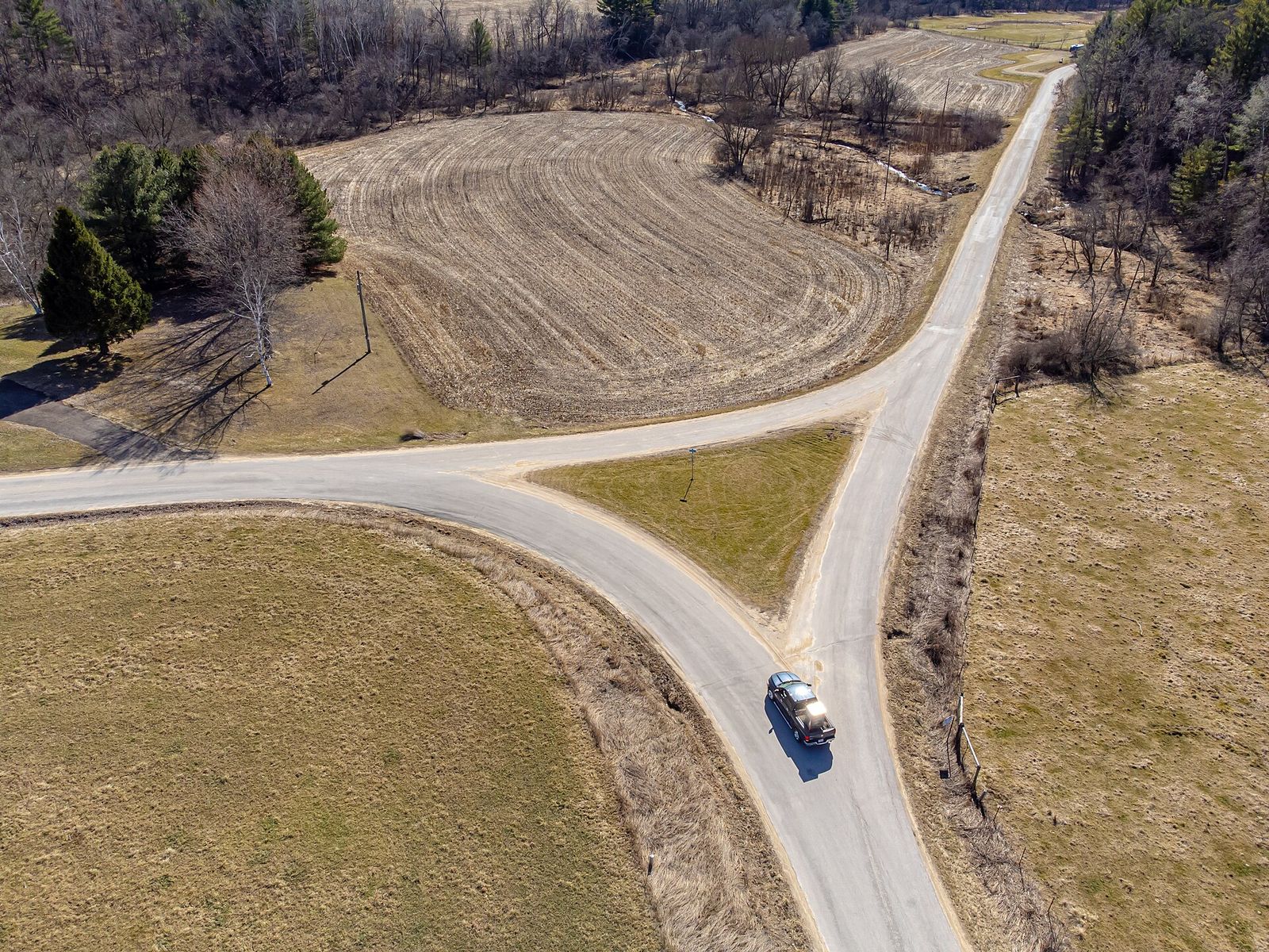Aerial view of a country road dividing in two at a grassy fork