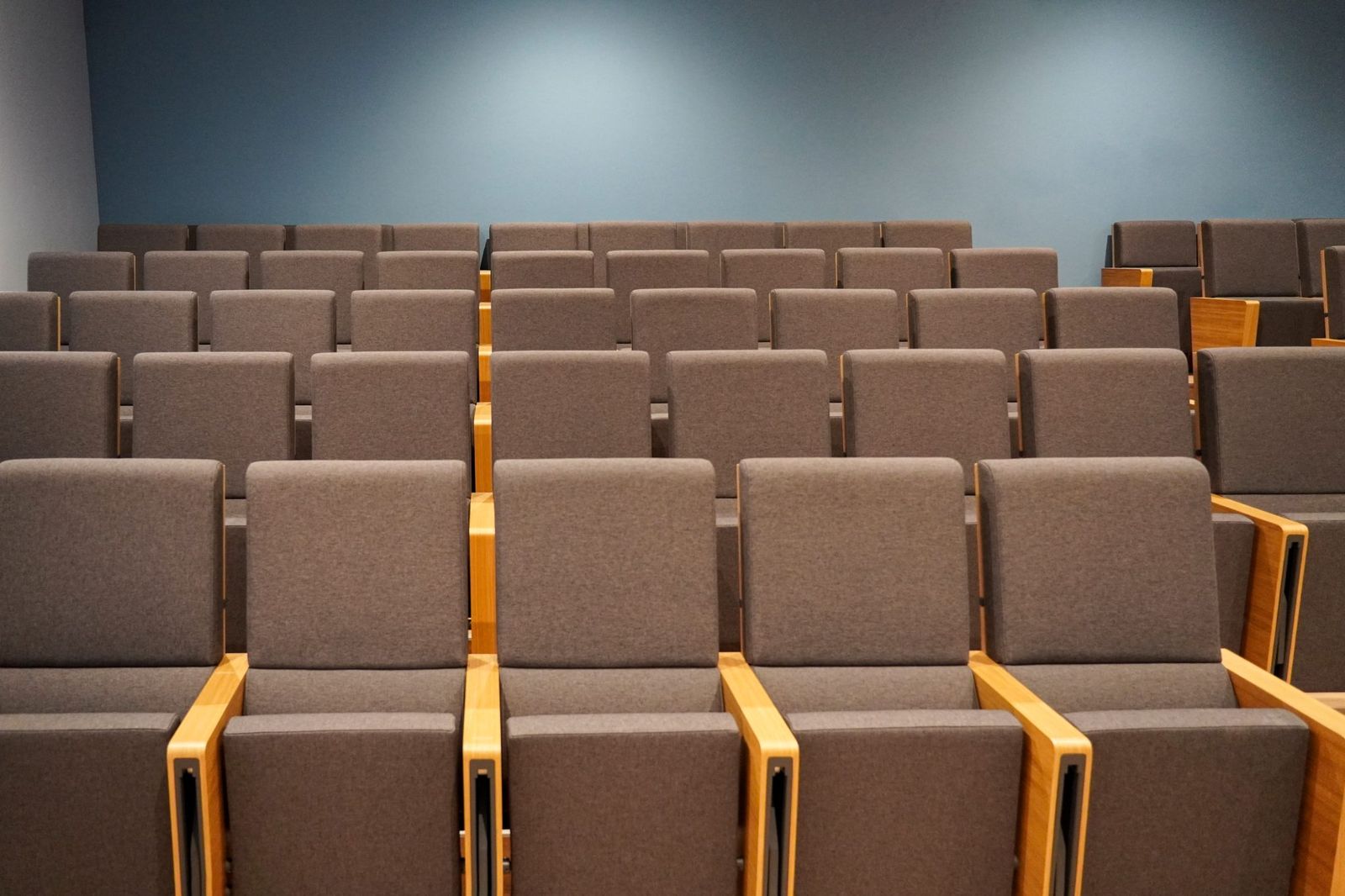 Rows of empty upholstered seats in a small lecture room